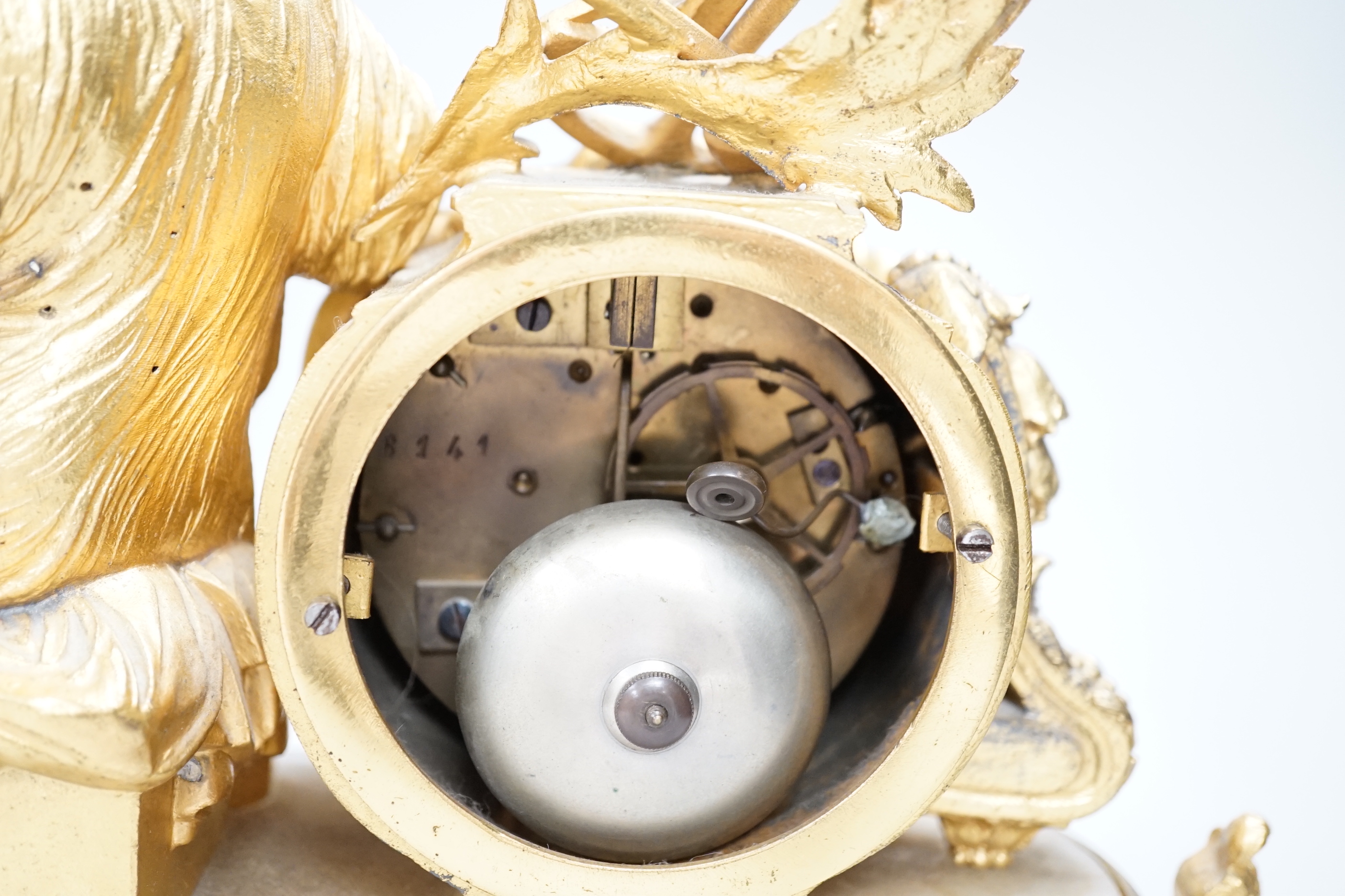 A late 19th century French gilt metal and onyx clock mounted with the figure of Industry holding a locomotive, 42cm wide